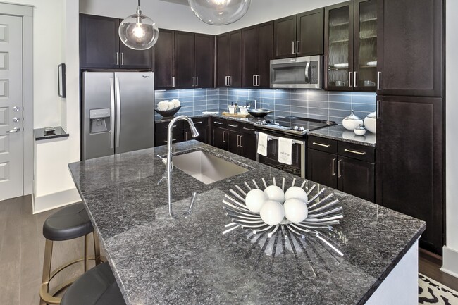 Stunning kitchens feature quartz countertops and custom-patterned tile backsplash. - Windsor Fitzhugh