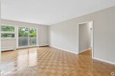 Located at 26-38 Carluke Crescent in Toronto's desirable North York neighbourhood, this well-laid-out 3-bedroom, 2-bathroom unit offers a comfortable and functional living environment across a single floor. Classic parquet hardwood flooring runs throughout the living areas and all three bedrooms, lending warmth and character to each room. The open living and dining area is generously proportioned, featuring sliding glass doors that lead to a private balcony overlooking mature green trees, filling the space with natural light. The galley-style kitchen is efficiently designed with white cabinetry, marble-patterned countertops, tile flooring, and stainless steel appliances including an electric range and refrigerator. The primary bedroom is a comfortable size and benefits from good natural light, while the additional bedrooms each feature windows with leafy outdoor views and baseboard heating. Storage is well addressed throughout, with a dedicated walk-in closet fitted with built-in shelving and hanging space, as well as a sliding-door closet in one of the bedrooms. Both bathrooms are finished with marble-patterned vanity tops and tile flooring, maintaining a clean and cohesive aesthetic. A hallway connects all rooms efficiently, completing this practical and inviting home.