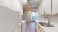 Located at 411 Gateway Dr in Pacifica, CA, this single-floor unit offers a practical and well-organized layout highlighted by consistent light wood-style flooring and neutral wall tones throughout. The galley-style kitchen is efficiently designed with white cabinetry lining both sides, providing ample upper and lower storage. White appliances, including a refrigerator and electric range, are complemented by a stainless steel sink with a window view at the far end. A ceiling fan and track lighting add both comfort and functionality to the space.

The living area is open and inviting, featuring a textured ceiling, a ceiling fan, and large sliding glass doors with vertical blinds that allow generous natural light and provide access to an outdoor area. Baseboard heating is present throughout, ensuring consistent warmth. The layout flows naturally from the living space into additional rooms, as seen in the floor plan.

The bedrooms are bright and simply finished, each with windows that bring in natural light and baseboard heaters along the walls. The bathrooms are clean and functional — one features a wide vanity with ample cabinet storage, a large mirror with overhead lighting, and a separate toilet room, while the second bathroom includes a tub and shower combination with sliding glass doors and wood-style flooring.