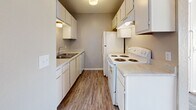 Located at 9300 Orchard Blvd in Midwest City, Oklahoma, this one-bedroom, one-bathroom unit offers a practical and well-organized single-floor layout. The combined living, dining, and kitchen area forms the heart of the unit, featuring neutral-toned walls, a textured ceiling, and plush wall-to-wall carpeting in the living and dining spaces. A sliding glass door with vertical blinds opens to a balcony, allowing natural light to fill the room and providing outdoor views of the surrounding neighborhood.

The galley-style kitchen is efficiently designed with white cabinetry lining both sides, laminate countertops, a stainless steel sink, and white appliances including an electric range and refrigerator. Wood-look vinyl flooring runs throughout the kitchen, adding a clean, durable finish.

The bedroom is a comfortable, well-proportioned space with soft carpet underfoot, a ceiling fan with a light fixture, and a window that brings in additional natural light. Two closets provide ample storage, and direct access to the hallway connects seamlessly to the rest of the unit.

The bathroom is appointed with a full tub-shower combination, a vanity with storage cabinetry above, and wood-look flooring. A dedicated utility room adds functional value to the overall layout. Textured ceilings are consistent throughout the unit.