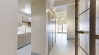 Located at 317 Lexington Ave in San Antonio, Texas, this one-bedroom, one-bathroom unit offers an industrial-modern aesthetic with a thoughtfully organized layout. The spacious main living area is a standout, featuring soaring exposed beam ceilings, a ceiling fan, and polished painted concrete floors that lend an urban loft character to the space. Large sliding glass doors flood the room with natural light and open to a private balcony framed by corrugated metal paneling and bold red railings, offering open views of the surrounding building courtyard.

The galley-style kitchen is efficiently designed with taupe cabinetry, a stainless steel refrigerator, electric range, built-in dishwasher, and a modern faucet over a single-basin sink with light countertops. A hallway connects the main living areas to the generously sized bedroom, which continues the concrete floor aesthetic and benefits from high ceilings and exposed structural elements.

The bathroom features a long vanity with white countertops, warm taupe cabinetry, and a combined tub and shower with accessibility grab bars. A dedicated laundry room with washer and dryer hookups and overhead wire shelving adds everyday convenience to this well-appointed urban residence.
