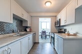 Located at 200 Dennistoun St in Welland, Ontario, this 1-bedroom, 1-bathroom unit offers a thoughtfully designed single-floor layout with a comfortable and practical flow throughout. The open-concept living and dining area is bright and welcoming, anchored by a large floor-to-ceiling window that fills the space with natural light and provides pleasant views of the surrounding greenery. The living room features neutral carpet flooring and a textured ceiling, creating a cozy yet airy atmosphere. The adjacent dining area comfortably accommodates a round dining table and benefits from its own window overlooking the outdoors. The kitchen is efficiently designed with white cabinetry, light countertops, a double stainless steel sink, a stainless steel dishwasher, and a striking herringbone-patterned metallic tile backsplash that serves as a stylish focal point. The generously sized primary bedroom features large windows with vertical blinds, soft carpet flooring, and a built-in sliding-door closet offering ample storage. A dedicated office space provides flexibility for work or hobbies, also equipped with a built-in closet. The full bathroom includes a vanity with storage, a combination tub and shower, and tile flooring. Two hallways connect the rooms seamlessly, completing this well-organized and comfortable unit.