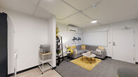 Located at 1612 Sisk Rd in Modesto, California, this efficiently designed single-floor unit makes smart use of its compact footprint across three distinct areas. The living space serves as the heart of the unit, featuring carpet flooring, a wall-mounted mini-split HVAC system for year-round climate control, and track lighting along the ceiling. Vertical blinds on the window allow for adjustable natural light. The room is styled with a neutral gray and yellow palette, creating a warm and inviting atmosphere. A structural column subtly divides the living area from the kitchenette, which is outfitted with gray shaker-style cabinetry, a light-toned countertop, a built-in sink, and a compact cooktop. A full-size refrigerator and light wood-look flooring complete the kitchen area, giving it a clean and practical feel. Adjacent to the main living space is a dedicated closet room featuring a clothes hanging rod, light wood-look flooring, a textured accent wall with white brick-style paneling, and a window with horizontal blinds that allows natural light to filter in. The overall design of the space is modern and cohesive, with a bright white color scheme throughout that enhances the sense of openness.
