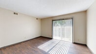 Located at 2768 S Seneca St in Wichita, Kansas, this single-floor, two-bedroom, one-bathroom unit offers a practical and well-organized layout. The living room features dark hardwood-style flooring and a large sliding glass door fitted with vertical blinds, allowing generous natural light to fill the space and providing outdoor access. A textured ceiling runs throughout, adding a classic residential character.

The kitchen is efficiently designed with a galley-style layout, featuring gray cabinetry, light granite-look countertops, tile flooring, and white appliances including a refrigerator and range. Ample upper and lower cabinet storage makes the kitchen highly functional.

Both bedrooms are carpeted for comfort. The primary bedroom is notably well-lit, benefiting from two windows and a ceiling fan with light fixture. The second bedroom also features a window with views to the outdoors, providing natural light and ventilation.

The full bathroom is tiled throughout, with a tub/shower combination featuring floor-to-ceiling tile surround with a decorative mosaic accent border, complemented by a vanity with storage. A hallway and closet round out the layout, contributing to practical everyday storage. This unit offers a straightforward, functional design suited for comfortable everyday living.