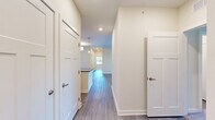 Located at 1000 Banner Dr in Gallatin, TN, this single-story home offers four bedrooms, two bathrooms, and three closets across a well-designed floor plan. The open layout is anchored by a combined kitchen and living room area, where wood-look luxury vinyl plank flooring runs throughout the main spaces, complemented by soft neutral wall tones that create a bright, welcoming atmosphere.

The kitchen features white shaker-style cabinetry, dark granite countertops, a stainless steel dishwasher, and a peninsula that provides additional counter space and separates the kitchen from the living area. The living room is generously sized, fitted with a ceiling fan, and opens directly to an outdoor balcony through glass-paneled doors, allowing for natural light and outdoor views.

Both bathrooms are finished consistently, each showcasing white shaker vanity cabinets, dark granite countertops, large mirrors with contemporary light fixtures, and wood-look tile flooring. The bedrooms vary in size, with the primary bedroom offering a comfortable footprint, while additional bedrooms feature either plush carpeting or hard flooring and windows that invite natural light. Three closets provide ample storage throughout the home. The clean, modern finishes and cohesive design make this a well-appointed residence.