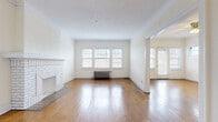 Located at 2816 Mayfield Rd in Cleveland Heights, OH, this one-bedroom, one-bathroom unit showcases classic architectural details that reflect its vintage character. Hardwood floors run throughout the single-level layout, catching natural light from the numerous windows positioned across the space.

The unit features two living areas connected by a distinctive arched doorway — a charming architectural element that adds elegance to the open flow between rooms. The larger living room includes a white-painted brick fireplace as a focal point, crown molding along the ceiling, and a cast-iron radiator beneath a trio of windows. The second living area offers a ceiling fan, additional windows, and a door providing exterior access.

The bedroom includes a ceiling fan, hardwood floors, natural light from dual windows, a dedicated closet with built-in shelving, and a radiator for heating. The kitchen features white cabinetry, a gas range, a refrigerator, and a patterned tile floor with a window overlooking the exterior. The bathroom retains its vintage character with white penny-tile flooring, full-wall tile surround, a vanity, and a shower-tub combination. In-unit laundry access and hallway storage complete the layout.