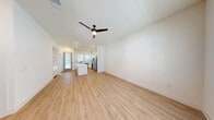 Located at 2611 E Braker Ln in Austin, TX, this contemporary two-story home offers four bedrooms and four bathrooms across two well-proportioned floors. The main level features an open-concept kitchen and living area with light wood-look flooring, recessed lighting, and a ceiling fan. The kitchen is a standout, showcasing crisp white shaker cabinets with matte black hardware, a large central island with quartz countertops, subway tile backsplash, stainless steel appliances, and a window overlooking the exterior. The bathrooms continue the modern aesthetic with white cabinetry, quartz counters, matte black fixtures, and wood-look flooring. The bedrooms are carpeted and feature ceiling fans; several include multiple windows that invite natural light and outdoor views. One bedroom on the upper level provides access to a dedicated closet. A staircase connects the two floors, with the upper level offering additional private bedroom and bathroom space. Throughout the home, a consistent palette of bright white walls, clean lines, and matte black accents creates a cohesive, modern atmosphere suited for comfortable everyday living in Austin.