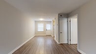 Located at 1040 McQuay St in Charlotte, NC, this single-floor residence offers a clean, updated interior with a cohesive and neutral design palette throughout. The living area is open and welcoming, featuring warm wood-look vinyl plank flooring, crisp white trim, and natural light streaming in through windows dressed with horizontal blinds. The layout flows efficiently, with a central hallway connecting the main living spaces to the private areas of the home.

The kitchen is well-appointed with white shaker-style cabinetry, granite-look countertops, a stainless steel sink, and a white range with overhead ventilation. A window above the counter allows natural light to brighten the workspace, making it both functional and inviting.

The bedrooms are comfortably sized, each featuring the same wood-look flooring, neutral gray-toned walls, and windows that offer views of the surrounding neighborhood. The rooms provide a versatile, move-in-ready canvas.

The bathroom includes a tiled tub-shower combination with classic white square tile, a granite-topped vanity with white cabinetry, and a window that provides natural ventilation and light. Brushed nickel hardware and fixtures add a modern, cohesive touch throughout. The overall ambiance of the home is clean, bright, and practical.