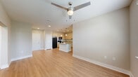 This well-appointed 2-bedroom, 2-bathroom unit at 6795 Powers St in Riverdale, GA offers a thoughtfully designed single-level layout with modern finishes throughout. The open-concept kitchen and living area serves as the heart of the home, anchored by a central island with granite countertops and elegant pendant lighting. Light wood cabinetry, black appliances, and recessed lighting complete the kitchen's clean, contemporary aesthetic. Wood-style plank flooring extends throughout the main living areas, adding warmth and continuity to the space. The living room offers generous proportions, complemented by a ceiling fan and natural light from a window. Both bedrooms feature plush carpet flooring, ceiling fans, and windows that allow natural light to filter in. The primary bedroom is a comfortable retreat with direct access to a closet and a hallway connecting to the rest of the unit. The bathrooms are finished with granite-top vanities, wood-toned cabinetry, tile flooring, and large mirrors with modern lighting fixtures. A dedicated closet and hallway provide practical storage and circulation. Neutral tones throughout create a bright, inviting ambiance suitable for a variety of living styles.