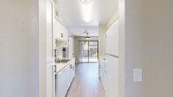 Located at 6016 Sunrise Vista Dr in Citrus Heights, CA, this one-bedroom, two-bathroom unit offers a well-organized, single-floor layout designed for comfortable everyday living. Light wood-style flooring flows throughout, complementing the neutral warm-gray walls and textured ceilings found across the home.

The kitchen is a standout feature, outfitted with crisp white shaker cabinetry, black hardware accents, a stainless steel sink, and white appliances including a refrigerator and dishwasher. It opens toward the combined living and dining area, which benefits from abundant natural light streaming in through a large sliding glass door that leads directly to a private patio — ideal for outdoor relaxation. A ceiling fan overhead adds to the comfort of the living space.

The bedroom is a well-proportioned, quiet retreat with a sizable window that allows natural light and outdoor views. A dedicated closet provides ample storage. The hallway connecting the rooms includes additional built-in cabinetry, offering practical storage solutions. Both bathrooms are clean and functional, with one featuring a full soaking tub and shower combination with a window above.

An in-unit laundry room adds everyday convenience, and the space includes its own electrical panel. The overall ambiance is bright, clean, and move-in ready.