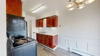 Located at 795 Wagner Dr in Battle Creek, Michigan, this single-floor unit offers a practical and well-organized layout designed for comfortable everyday living. The kitchen serves as a functional centerpiece, featuring rich warm-toned wood cabinetry, light countertops, a double-basin sink, and full appliances including a refrigerator, electric range, and dishwasher. Light wood-style flooring runs throughout the kitchen, which also includes wainscoting detail and a decorative chandelier overhead. The spacious living area is finished with neutral carpet and benefits from a large window with vertical blinds that allows natural light to fill the room. A wall-mounted air conditioning unit and baseboard heating provide year-round climate control. The bedrooms are carpeted and bright, each offering generous proportions. One bedroom features mirrored sliding closet doors with built-in rods and a ceiling fan, while another offers a ceiling fan and a large window. A carpeted hallway connects the rooms and includes convenient built-in wall shelving. The full bathroom is cleanly appointed with white tile surrounding the tub-shower combination, a granite-topped vanity, and wood-style flooring, creating a cohesive and tidy finish throughout the space.