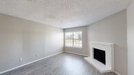 Located in Saginaw, Texas, this single-story 2-bedroom, 3-bathroom home offers a well-organized layout with a comfortable, neutral aesthetic throughout. The combined living and dining area serves as the heart of the home, featuring wood-look laminate flooring, a textured ceiling, and a white brick fireplace that anchors the space. A large window floods the room with natural light and provides views of the surrounding neighborhood, while a front entry door opens directly into this welcoming common area. The galley-style kitchen is efficiently designed with white cabinetry, speckled countertops, a stainless steel double-basin sink, and a stainless steel refrigerator. A window above the sink adds natural light, and a pantry provides additional storage. A dedicated laundry area and hallway connect the main living spaces to the private quarters. Both bedrooms are carpeted and feature ceiling fans with integrated lighting. The primary bedroom offers a comfortable footprint with natural light from a large window. Three bathrooms include tiled tub-shower combinations with clean white fixtures. Two closets provide ample storage. The home's consistent use of soft gray tones and practical finishes creates a cohesive, move-in-ready environment.