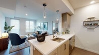 Located at 6801–6835 Alabama Ave in the Canoga Park neighborhood of Los Angeles, this single-floor residence showcases a contemporary design with a cohesive, modern aesthetic throughout. The open-concept layout connects the kitchen and living area seamlessly, creating a fluid and functional living space filled with natural light from multiple windows dressed with clean white blinds.

The kitchen is outfitted with stainless steel appliances, including a full-size refrigerator, range, and microwave. Light wood cabinetry pairs with a bright white quartz countertop and a central island featuring a stainless steel sink, complemented by stylish pendant lighting overhead. A white subway tile backsplash adds a clean, polished detail.

The living area is bright and open, with wood-style flooring and access to an outdoor area through a glass door. A secondary room provides additional flexible living space, also benefiting from natural light.

The bedroom features plush carpeting, a multi-window bay configuration that invites ample daylight, and a spacious closet. The bathroom is finished with light wood vanity cabinetry, a white countertop, and a walk-in shower, maintaining the unit's consistent modern style throughout.
