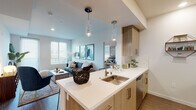 Located at 6801–6835 Alabama Ave in the Canoga Park neighborhood of Los Angeles, this single-floor residence showcases a contemporary design with a cohesive, modern aesthetic throughout. The open-concept layout connects the kitchen and living area seamlessly, creating a fluid and functional living space filled with natural light from multiple windows dressed with clean white blinds.

The kitchen is outfitted with stainless steel appliances, including a full-size refrigerator, range, and microwave. Light wood cabinetry pairs with a bright white quartz countertop and a central island featuring a stainless steel sink, complemented by stylish pendant lighting overhead. A white subway tile backsplash adds a clean, polished detail.

The living area is bright and open, with wood-style flooring and access to an outdoor area through a glass door. A secondary room provides additional flexible living space, also benefiting from natural light.

The bedroom features plush carpeting, a multi-window bay configuration that invites ample daylight, and a spacious closet. The bathroom is finished with light wood vanity cabinetry, a white countertop, and a walk-in shower, maintaining the unit's consistent modern style throughout.