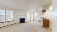 Located at 991 S Crystal Way in Aurora, Colorado, this two-bedroom, one-bathroom residence offers a comfortable and functional single-floor layout. The open-concept living and dining area serves as the heart of the home, anchored by a classic wood-burning fireplace with a tile surround and a wood mantel. Soft carpeting, neutral walls, and a ceiling fan contribute to the room's relaxed ambiance, while windows and a glass-paned door flood the space with natural light and provide direct access to a covered balcony overlooking the tree-lined surroundings. The kitchen features warm wood cabinetry, a double-basin stainless steel sink, and a peninsula with a laminate countertop — ideal for casual dining or meal prep. White appliances and a dedicated range hood round out the practical layout. Both bedrooms are carpeted and well-proportioned, each offering closet access and natural light through bright windows. The primary bedroom provides a comfortable retreat with ample closet space. The full bathroom includes a granite-style vanity countertop, wood-accented medicine cabinets, a large mirror, and a tub/shower combination with tile surround set on stone-look tile flooring. Six closets throughout the unit ensure generous storage across the floor plan.