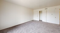 Located in Dallas, TX, this one-bedroom, one-bathroom unit offers a well-organized single-floor layout designed for comfortable, everyday living. The open-concept living and dining area is bright and inviting, featuring plush wall-to-wall carpeting and a large sliding glass door dressed with vertical blinds that fills the space with natural light and provides access to an outdoor view. A pass-through kitchen connects seamlessly to the living area, featuring warm wood-toned cabinetry, a refrigerator, and a built-in shelving unit — ideal for displaying décor or storing essentials. The kitchen also includes hard surface flooring for easy maintenance. The spacious bedroom is carpeted and appointed with a ceiling fan and light fixture, a window that brings in additional natural light, and convenient closet access. Notably, the unit boasts an impressive five closets throughout, including a generously sized walk-in closet with built-in shelving and hanging rods, offering exceptional storage capacity. The bathroom features a full tub-shower combo with white tile surround, wood-toned cabinetry, a speckled countertop vanity, and wood-look flooring. A dedicated entrance, hallway, and thoughtful layout round out this functional and cozy Dallas residence.