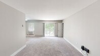 Located at 400 Matawan Ave in Cliffwood, NJ, this single-floor residence offers a well-designed layout with thoughtfully updated finishes throughout. The living areas are generously sized, featuring plush neutral-toned carpeting, clean white baseboards, and soft gray walls that create a calm, cohesive atmosphere. Large sliding glass doors in both the living room and an additional room provide direct access to a private balcony, filling the interior with natural light and offering pleasant views of mature surrounding greenery.

The kitchen stands out with rich, dark wood cabinetry on both upper and lower levels, complemented by sleek silver hardware, crisp white quartz countertops, and a stylish gray subway tile backsplash. Stainless steel appliances complete the modern aesthetic, while wood-look flooring grounds the space practically and visually.

The bedrooms are well-proportioned with soft carpeting and ample closet space, including walk-in and standard closets with built-in rods for organization. Each room benefits from natural light through windows fitted with blinds.

The bathroom is a refined highlight, finished with large-format marble-look tile covering the walls of the tub surround, a built-in niche, and chrome fixtures — lending an elegant, spa-like quality. The overall space presents a clean, move-in-ready environment with modern updates and comfortable, functional design throughout.