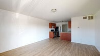 Located at 902 Gum Branch Rd in Jacksonville, NC, this single-floor, one-bedroom, one-bathroom unit offers a practical and well-organized layout. The open-concept living and kitchen area serves as the heart of the home, with light wood-style flooring flowing throughout, white walls, and flush-mount ceiling lighting that keeps the space feeling bright and clean. A bold black front door welcomes you into the living area, which features a window that brings in natural light and views of the surrounding exterior.

The kitchen is equipped with warm-toned, medium wood cabinetry, granite-look countertops, stainless steel appliances including a range and refrigerator, and a peninsula that separates it from the living area — providing both additional counter space and an informal dining or prep area. A sink is integrated into the peninsula for added convenience.

The bedroom offers a comfortable footprint with the same light wood-style flooring, a built-in closet with a hanging rod, and an electrical panel tucked neatly into the wall. An additional door in the bedroom provides access to a secondary space or utility area.

The bathroom includes a full tub-shower combination, a vanity with storage, and dark wood-style flooring, completing this straightforward and functional unit.
