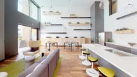 Located at 1910 S Union St in Anaheim, California, this single-floor communal amenity space is a thoughtfully designed environment that blends modern aesthetics with functional gathering areas. The interior is characterized by soaring ceilings, rich hardwood flooring, and an open-plan layout that connects multiple zones seamlessly.

The main lounge area features contemporary sectional seating in neutral tones accented by vibrant yellow chairs and green area rugs, creating an inviting social atmosphere. A wall-mounted flat-screen television and a sleek built-in fireplace serve as focal points, while globe pendant lights add a stylish, modern touch throughout.

The kitchen and bar area is outfitted with crisp white quartz countertops, dark wood cabinetry, a matte black sink fixture, and under-counter appliances. Staggered open shelving adorned with live succulent planters in natural wood boxes adds a biophilic design element that runs throughout the space.

A game room with a full-size billiards table and warm wood flooring is accessible via large glass-and-steel doors that open directly to an outdoor courtyard. The courtyard features concrete tile flooring, bold yellow seating, architectural planter boxes, and a shade sail, offering a bright and comfortable al fresco gathering space.

The entry corridor is finished in neutral large-format tile and features glass-panel doors leading to private rooms and additional amenity areas, with colorful artwork accenting the clean white walls.