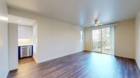This well-designed 2-bedroom, 1-bathroom residence offers a thoughtful single-floor layout that makes efficient use of its space. The galley-style kitchen is a standout feature, showcasing bold navy blue lower cabinetry paired with crisp white upper cabinets and white countertops. Stainless steel appliances — including a full-size refrigerator, electric range, built-in microwave, and dishwasher — complete the modern aesthetic. A tall window at the end of the kitchen brings in natural light and outdoor views of surrounding greenery.

The living room is open and airy, finished with warm wood-style vinyl plank flooring that extends throughout the main living areas. A ceiling fan adds comfort, while a sliding glass door leads to a private balcony overlooking lush trees, creating a seamless indoor-outdoor connection.

The primary bedroom continues the wood-style flooring and features its own sliding glass door to the balcony, a ceiling fan, and ample natural light. The second bedroom is carpeted and cozy, with a window and a clean, neutral palette. Both bedrooms offer a calm, versatile space.

The bathroom is cleanly finished with a blue vanity cabinet, white countertop, wall-mounted lighting, a full mirror, and a shower-tub combo. Neutral tones and recessed lighting throughout the unit create a cohesive, contemporary ambiance.