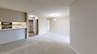 This single-story, 2-bedroom, 1-bathroom home in Columbus, Georgia offers a practical and comfortable layout. The combined kitchen and living area forms the heart of the home, with the kitchen featuring wood-style flooring, white cabinetry, stainless steel appliances including a Whirlpool refrigerator, and a peninsula with wainscoting detail that opens to the living space. The living room is carpeted and centers around a white-mantled fireplace flanked by built-in shelving and cabinetry — a standout feature that adds both character and functional storage. A pendant light fixture and textured ceiling complete the living area. Both bedrooms are carpeted and filled with natural light from windows fitted with blinds; ceiling fans are present for added comfort. The primary bedroom is generously sized, while the second bedroom offers a cozy, versatile space. The bathroom includes a full soaking tub with a shower, built-in niche, and vanity with mirror. A dedicated closet provides additional storage. Neutral warm tones and clean finishes throughout create a cohesive and move-in-ready atmosphere.