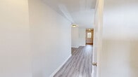Located at 401 Talcottville Rd in Vernon Rockville, CT, this single-floor, one-bedroom, one-bathroom unit offers a well-organized and functional layout. Light wood-style plank flooring runs throughout the main living areas, complemented by neutral white walls and textured ceilings that give the space a clean, bright feel.

The open-concept kitchen and living room area forms the heart of the unit. The kitchen features warm wood-toned cabinetry, light countertops, tile flooring, a gas range, a dishwasher, and a refrigerator. A door with a window in the kitchen provides natural light and exterior access. The adjoining living area is generously proportioned, with large windows that invite ample natural light and offer views of the surrounding greenery.

A hallway connects the main living space to the private bedroom, which is a well-sized room featuring two windows that bathe the space in natural light. Three closets throughout the unit provide notable storage capacity. The bathroom includes a wood-toned vanity, tile flooring, and a window for natural ventilation. A utility room and dedicated hallway round out the layout, adding further practicality to this efficiently designed single-story home.