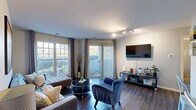 Located along Lakeshore Trail E Drive in Indianapolis, this one-bedroom, one-bathroom residence offers a well-designed single-floor layout that maximizes every square foot of its compact footprint. The open-concept living and kitchen area forms the heart of the home, filled with natural light from large windows and a sliding glass door that opens to the outdoors. Rich, dark hardwood-style flooring runs throughout the living space, complementing the neutral wall tones and creating a warm, cohesive aesthetic. The kitchen is a standout feature, boasting dark espresso cabinetry, granite-look countertops with a subway tile backsplash, black appliances, and a functional breakfast bar. A walk-in pantry provides generous storage. The bedroom features plush carpeting, a sliding glass door for additional natural light, and a dedicated closet with built-in shelving for organized storage. A dresser area with wall-mounted mirrors adds practical elegance. The bathroom is clean and bright, complete with a full tub-shower combination with white tile surround, a vanity with dark cabinetry, and wood-style flooring. Track lighting and thoughtful finishes throughout give the space a modern, move-in-ready appeal suited for comfortable everyday living.