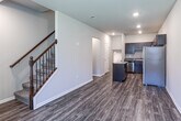 Located on Shelby Parkway in Shelby Township, Michigan, this contemporary multi-floor residence offers a well-designed layout spread across three levels. The entry level welcomes you with durable wood-look flooring, natural light streaming through front-facing windows with vertical blinds, and a striking staircase with dark wood railings and decorative wrought iron balusters. The open-concept main living area flows seamlessly into a well-appointed kitchen featuring rich dark espresso cabinetry, granite countertops, a center island with additional counter space, and a full suite of stainless steel appliances including a refrigerator, range, microwave, and dishwasher. The bathrooms are finished with granite-topped dark wood vanities, large-format tile flooring, and tiled shower surrounds — one featuring a walk-in shower and another with a soaking tub. Additional levels provide flexible living space, including a lower-level room with wood-look flooring and a window, as well as a utility and storage area with an electrical panel and water heater. The attached garage offers generous space with an automatic door opener and direct interior access, completing this thoughtfully designed residence.