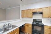 Located at 9701 Summit Cir in Upper Marlboro, MD, this well-designed three-bedroom, two-bathroom residence offers a comfortable and functional single-floor layout. The spacious living room serves as the heart of the home, featuring elegant crown molding, plush wall-to-wall carpeting, and a classic fireplace with a white surround and dark stone hearth. Sliding glass doors lead to a private balcony overlooking lush greenery and manicured grounds.

The kitchen is equipped with warm honey-toned cabinetry, white countertops, and black appliances including a range, refrigerator, and dishwasher. A peninsula with a breakfast bar seamlessly connects the kitchen to the living area, and light wood-look flooring ties the space together.

The three bedrooms are generously proportioned, each featuring soft carpeting and windows with blinds that invite natural light. The primary bedroom offers ample space and is complemented by two closets throughout the residence. The two bathrooms are clean and functional, featuring wood-look flooring, white vanities with mirrors, and tub-shower combinations — one equipped with accessibility grab bars for added convenience. A dedicated entrance provides a welcoming transition into the home.