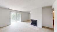 Located at 7909 Coventry Ct in Evansville, Indiana, this single-floor, one-bedroom, one-bathroom apartment offers a functional and comfortable layout. The living room serves as the heart of the space, highlighted by a wood-burning fireplace with a tiled hearth that adds warmth and character. A full-width sliding glass door fitted with vertical blinds floods the room with natural light and provides views of the greenery outside. Soft carpeting extends throughout the living and bedroom areas, contributing to a cozy atmosphere, while a textured ceiling adds a classic residential touch. The kitchen is equipped with warm oak cabinetry, a double-basin stainless steel sink, light-toned countertops, a dishwasher, and tile flooring, providing a practical workspace. The bedroom is a well-proportioned retreat featuring carpeted floors, a window with blinds for natural light and privacy, and easy access to a dedicated closet. The bathroom includes a full tub-shower combination with clean white tile surround, a toilet, and tile flooring. A hallway connects the rooms efficiently, and warm-toned wooden interior doors are found throughout. The overall aesthetic is clean, neutral, and move-in ready.