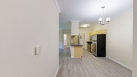 Located at 721 S Cherry Grove Ave in Annapolis, Maryland, this well-appointed 2-bedroom, 2-bathroom residence offers a thoughtful single-floor layout finished with light luxury vinyl plank flooring and crown molding throughout. The living room serves as the heart of the home, anchored by a tile-surround fireplace and a sliding glass door that opens to a private balcony with wooded views. An adjacent dining area features a chandelier and built-in shelving, adding a touch of character to the space. The kitchen is designed for functionality, featuring an open peninsula with dark countertops, a stainless steel refrigerator, gas range, and built-in microwave, all framed by warm honey-toned cabinetry. Both bedrooms offer calm, neutral tones and ample natural light; the primary bedroom is generously sized and includes a dedicated closet. The two bathrooms are cleanly finished with tub-shower combinations, light wood-look flooring, and dark-countered vanities. A dedicated laundry area with a full-size washer and dryer adds everyday convenience. Crown molding and consistent finishes lend a cohesive, polished feel throughout this comfortable Annapolis residence.