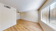 Located at 3555 Stober Blvd in Las Vegas, Nevada, this one-bedroom, one-bathroom unit offers a compact and efficiently designed single-floor layout. Throughout the space, light-toned wood laminate flooring provides a clean, cohesive look that brightens every room.

The living area serves as the welcoming heart of the unit, featuring a ceiling fan with light fixture, a textured ceiling, and a large window fitted with blinds that allows natural light to filter in. The entry area also benefits from a window overlooking a lush outdoor greenery view, adding a refreshing natural element to the interior.

The bedroom is an intimate, well-proportioned room with its own window framing views of surrounding trees and greenery, a textured ceiling, and the same warm wood flooring found throughout. A dedicated closet provides practical storage space.

The bathroom is neatly appointed with a full tub and shower combo featuring white subway tile surround and chrome grab bars, complemented by a vanity with a dark stone-style countertop, an undermount sink, and a wood-framed mirror. The wood flooring continues seamlessly into this space.

Overall, the unit presents a clean, neutral palette with consistent finishes, making it a straightforward and functional living space in Las Vegas.