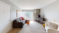 This single-floor residence in Glendale Heights, Illinois, offers a well-organized and functional layout across its living spaces. The open living room is generously sized, featuring soft carpeting, a ceiling fan, and a large sliding glass door that floods the space with natural light and provides outdoor views. The adjoining dining area accommodates a full dining set, creating a seamless flow between relaxing and entertaining spaces.

The kitchen is equipped with rich dark cabinetry, black appliances including an electric range, built-in microwave, and dishwasher, complemented by light countertops and durable wood-look flooring. The layout is efficient and practical for everyday use.

The primary bedroom is a comfortable retreat with a bold accent wall, carpeted floors, a window with natural light, and two generous closets offering ample storage. A second bedroom features carpeting, a window, and flexible space suitable as a guest room or home office. A third, cozier bedroom also benefits from abundant natural light through a large window.

The full bathroom is finished in neutral tones with a tub-shower combination, a vanity with mirror, and clean white fixtures. Throughout the residence, a consistent warm gray color palette and carpeted living areas contribute to a cohesive and comfortable ambiance.