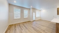 Located at 265 N Hamlin Avenue in Eagle, Idaho, this thoughtfully designed one-bedroom, one-bathroom unit offers a clean, modern aesthetic throughout its single-floor layout. The open-concept kitchen and living area serves as the heart of the home, featuring light luxury vinyl plank flooring, recessed lighting, and multiple windows with blinds that fill the space with natural light. Decorative board-and-batten wall paneling adds a stylish architectural detail to both the living area and adjoining rooms.

The kitchen is well-appointed with warm wood-toned cabinetry, crisp white quartz countertops, a undermount sink, and a full suite of stainless steel appliances including a range, over-the-range microwave, and refrigerator. A peninsula provides additional counter space and a natural divide between the kitchen and living areas.

The bedroom offers plush carpeting and direct access to a spacious walk-in closet equipped with multi-level shelving and hanging rods for ample storage. The full bathroom includes a tiled tub-shower combo, wood-look LVP flooring, and a vanity with wood-toned cabinetry. A dedicated laundry room with side-by-side washer and dryer hookups and sliding barn-style doors adds everyday convenience to this well-organized home.