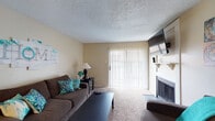 This single-floor residence offers a comfortable and practical layout designed for everyday living. The living room serves as the heart of the home, featuring plush carpeting, a classic fireplace with a tile surround and mantel shelf, a wall-mounted television, and a sliding glass door fitted with vertical blinds that allows natural light to pour in. The open sightlines from the living area connect seamlessly to the rest of the unit.

The kitchen is thoughtfully designed with white cabinetry, ample counter space, and a double sink. It opens to a dedicated dining area, which features carpeted flooring, a ceiling fan with lighting, and comfortable space for a full dining set — ideal for everyday meals or entertaining.

Both bedrooms are carpeted and well-proportioned, each equipped with a ceiling fan with light fixture and access to closet storage. The rooms offer a calm, neutral aesthetic with windows that allow natural light to filter through vertical blinds.

The bathroom features hardwood-style flooring, a full tub-shower combination, and clean, straightforward fixtures. Throughout the unit, textured ceilings, neutral warm-toned walls, and consistent carpeting create a cohesive and inviting atmosphere.