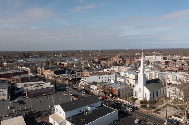 Town shops and a church overlook nearby water in Babylon for locals to enjoy.