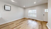Located at 407 Tuscany Ln in Baldwinsville, NY, this well-appointed two-story home offers three bedrooms and three bathrooms across two thoughtfully designed floors. Light hardwood flooring flows consistently throughout, complementing the neutral, soft-gray palette that lends a clean and modern aesthetic to every room.

The main level opens with a welcoming entryway featuring a classic paneled front door with window accent. The open-concept kitchen and living area is a standout highlight, anchored by a large granite-topped island with an integrated sink and pendant lighting above. White shaker-style cabinetry, a subway tile backsplash, stainless steel appliances, and recessed lighting complete the kitchen. Sliding glass doors allow natural light to pour into the adjoining living area.

Upstairs, three bedrooms offer comfortable retreats, each with hardwood flooring and windows that bring in natural light. The primary bedroom features a double-door closet and easy hallway access. The three bathrooms are finished with granite-topped white vanities and hardwood-style flooring, maintaining the home's cohesive design language.

An attached garage with an automatic opener provides convenient parking and additional storage. The overall ambiance is bright, clean, and move-in ready, reflecting modern finishes throughout.