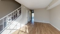Located at 600 Whispering Hills Dr in Nashville, Tennessee, this two-floor residence offers a well-organized layout across two levels connected by a carpeted staircase with a decorative white railing. The main level features hardwood-style flooring throughout the open living and dining areas, which benefit from natural light filtering through slatted blinds. The kitchen is equipped with white shaker-style cabinetry, marble-look countertops, and a full suite of black appliances including a refrigerator, dishwasher, and electric range, all set above durable wood-look flooring. A full bathroom on the upper level features white cabinetry, a tiled shower-tub combo, and wood-look flooring, maintaining a clean, bright aesthetic. The bedrooms are finished with plush, neutral-toned carpet and feature textured ceilings, ample wall space, and built-in ventilation. The upper-level bedrooms include closet access and open to a shared hallway. Neutral warm-gray wall tones are consistent throughout the home, creating a cohesive and move-in-ready atmosphere. The overall design is functional and clean, offering a comfortable living environment in a convenient Nashville location.
