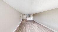 Located in the Clairemont neighborhood of San Diego, this well-appointed 1-bedroom, 1-bathroom unit offers a thoughtfully designed layout across a single floor. The open-concept living area is bright and welcoming, featuring light wood-style vinyl plank flooring, neutral warm-gray walls, and a textured ceiling. A ceiling fan adds comfort, while a large window frames outdoor greenery and fills the space with natural light. A built-in shelving unit provides functional display and storage space, seamlessly connecting the living area to the kitchen.

The kitchen is accessible via a peninsula-style pass-through, complete with gray cabinetry, stainless steel appliances, and a clean white countertop. The layout encourages an easy flow between cooking and living spaces.

The generously sized bedroom is carpeted for warmth and comfort, featuring neutral gray walls and a window with outdoor views, allowing natural light to filter in throughout the day.

The bathroom has been updated with crisp white shaker-style cabinetry, a white quartz countertop, a single undermount sink with matte black fixtures, and a full tub-shower combination. Clean lines and neutral tones give it a modern, polished feel.

The unit also includes a closet, hallway, and dedicated entry area, rounding out a complete and functional living space.