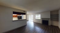 This single-story, 1-bedroom, 1-bathroom residence in Houston, TX offers a thoughtfully designed layout that maximizes functionality and comfort. The open-concept living and dining area is anchored by dark hardwood-style flooring, a textured ceiling, and a cozy fireplace with built-in shelving — a standout feature that adds character to the space. Natural light flows in through multiple windows fitted with horizontal blinds, as well as a sliding glass door that leads to an outdoor area. The galley-style kitchen is a highlight, boasting rich, dark cabinetry, granite-look countertops, stainless steel fixtures, and black appliances. A pass-through counter connects the kitchen seamlessly to the living area, enhancing the open feel. The spacious bedroom features plush wall-to-wall carpeting, a generous walk-in closet with built-in shelving and hanging rods, and a bright window that brings in natural light. The full bathroom is clean and functional, equipped with a white-tiled shower and tub combo, hardwood-style flooring, and brushed nickel hardware. Throughout the unit, a neutral color palette creates a bright, move-in-ready atmosphere.