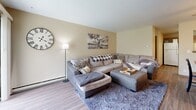 Located on Racine Ave in Muskego, Wisconsin, this single-floor, one-bedroom, one-bathroom unit offers a well-organized and functional layout. The open-concept living, dining, and kitchen area serves as the heart of the home. The living room features hardwood-style flooring, neutral warm-toned walls, and ample space for comfortable seating. Adjacent to it, the dining area is lit by a ceiling fan fixture and provides a welcoming space for everyday meals. The kitchen is equipped with warm wood cabinetry, granite-look countertops, a full suite of white appliances including a refrigerator, dishwasher, and range, and a pass-through window connecting to the dining area. The spacious primary bedroom includes two windows that bring in natural light, hardwood-style flooring, and enough room for a full bedroom set. A versatile office space accommodates a work-from-home setup alongside additional seating. The bathroom is neatly appointed with wood vanity cabinetry and open shelving. Connecting hallways provide smooth circulation throughout the unit. The overall aesthetic is clean and cohesive, with consistent flooring and neutral tones tying each room together seamlessly.