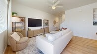 Located at 2627 N 83rd Ave in Phoenix, Arizona, this two-story home offers a well-organized layout spread across two floors. The main level features an open-concept kitchen and living room finished with warm light wood flooring. The kitchen is outfitted with white shaker cabinetry, stainless steel appliances including a full-size refrigerator, range, microwave, and dishwasher, complemented by clean white countertops and recessed lighting. The adjacent living room is bright and airy, featuring a ceiling fan and natural light from window treatments. A staircase leads to the upper level, which contains both bedrooms, additional bathrooms, a hallway, a dedicated office, and a closet. The generously sized primary bedroom is carpeted and bathed in natural light from multiple windows dressed with sheer curtains, and includes a ceiling fan. A well-appointed walk-in closet with built-in shelving and hanging rods offers ample storage. The secondary bedroom also features carpet and natural light. The flexible office space includes carpet, a window with outdoor views, and room for a desk and seating area. The four bathrooms maintain a clean, modern aesthetic with white finishes, light wood flooring, and simple fixtures throughout.