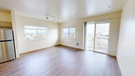 Located at 245 Tacoma Ave S, this generously laid-out 5-bedroom, 3-bathroom unit offers an impressive blend of functionality and comfort in the heart of Tacoma, WA. The open-concept living room is bathed in natural light from multiple large windows and a sliding glass door that leads to a private balcony, framing sweeping views of the waterfront and surrounding cityscape. Rich hardwood flooring and track lighting add a modern touch to the bright, neutral-toned space.

The kitchen is well-appointed with light wood cabinetry, stainless steel appliances including a refrigerator, electric range, and microwave, and a central island with a built-in sink — ideal for both everyday cooking and entertaining. Hardwood flooring flows throughout the main living areas, while bedrooms feature plush carpeting for added comfort. Each bedroom offers natural light through well-placed windows with views of the city and surrounding greenery.

The three bathrooms are finished with light wood vanities, countertops, and glass-enclosed showers, providing a clean and cohesive aesthetic. A dedicated laundry room houses a stacked washer and dryer, adding everyday convenience. The unit's single-floor layout ensures seamless flow between all spaces, making it a practical and comfortable home in a prime Tacoma location.