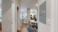 This contemporary 940 square foot apartment offers a harmonious blend of style and functionality. The open-concept design seamlessly integrates the kitchen, living, and dining areas, creating a spacious feel. The kitchen boasts modern appliances, including a stainless steel refrigerator and oven, complemented by a mix of white upper cabinets and warm wood lower cabinets. A convenient breakfast bar with stylish seating adds to the kitchen's appeal.

Both bedrooms are generously sized, with the primary bedroom measuring 160 square feet. Each room features large windows that allow ample natural light, enhancing the airy ambiance. The two full bathrooms are elegantly appointed with modern fixtures and finishes, including sleek vanities and ample storage.

The apartment's aesthetic is characterized by a neutral color palette, with warm wood flooring throughout, creating a cohesive look. Thoughtful touches like pendant lighting in the kitchen and ceiling fans in the bedrooms add both style and comfort. The in-unit laundry room and walk-in closets provide practical storage solutions.

Decorated with contemporary artwork and furnished with a mix of modern and mid-century inspired pieces, the space exudes a sophisticated yet comfortable atmosphere. The overall design promotes a sense of openness and flow, making this apartment an ideal urban retreat.