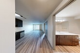 Located at 1111 E Union St in Seattle's vibrant Capitol Hill neighborhood, this modern 1-bedroom, 1-bathroom unit offers a well-designed, efficient layout with contemporary finishes throughout. Hardwood-style flooring runs continuously across the entire space, lending warmth and visual cohesion from room to room.

The open-concept kitchen and living area forms the heart of the unit. The kitchen is outfitted with rich dark-toned cabinetry reaching to the ceiling, sleek white countertops, a full suite of stainless steel appliances including a refrigerator, electric range, microwave, and dishwasher, and track lighting overhead. The living area extends toward a large picture window that fills the space with natural light and frames views of the surrounding urban streetscape.

The bedroom is a comfortable, well-proportioned retreat featuring a generous window with city views and access to two closets, one of which is a dedicated walk-in with built-in hanging rods. The combined bathroom and laundry room includes a full soaking tub with shower, light wood-toned cabinetry, and a white countertop vanity. Clean, neutral wall tones throughout the unit contribute to a bright and modern ambiance.