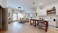Located at 1200 Marquis Pkwy in Williamsburg, VA, this well-appointed residence offers four bedrooms and two full bathrooms across a single floor. The open-concept layout connects the kitchen and living area seamlessly, creating an inviting, communal atmosphere filled with natural light from large windows dressed in sheer linen curtains.

The kitchen is outfitted with white shaker-style cabinetry, stainless steel appliances, a tile backsplash, open wood shelving, and a quartz countertop island with pendant lighting — ideal for both cooking and casual dining. The living room features light wood-style flooring, generous wall space, and access to a private exterior door.

The four bedrooms are carpeted for comfort and each benefits from natural light through sizable windows. The primary bedroom is a well-proportioned retreat, while the additional bedrooms offer flexibility for various living arrangements.

The two bathrooms are finished in a clean, contemporary style. One features a walk-in glass shower and white cabinetry with matte black hardware, while the second includes a tub-shower combination — both with light wood-style flooring and white vanities.

Throughout the residence, a neutral color palette, modern fixtures, and consistent finishes create a cohesive and functional living environment.