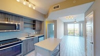 Located at 3300 N Port Royale Drive in Fort Lauderdale, this 2-bedroom, 2-bathroom residence offers a well-designed single-level layout with modern finishes throughout. The open-concept kitchen is a standout feature, showcasing wood-toned cabinetry, light-colored quartz countertops, a subway tile backsplash, and a full suite of stainless steel appliances including a refrigerator, range, microwave, and dishwasher. A central kitchen island provides additional prep and dining space, while track lighting overhead enhances the functional aesthetic.

The living area extends naturally from the kitchen and is bathed in natural light from floor-to-ceiling sliding glass doors that open to a private balcony with views of the surrounding Fort Lauderdale landscape, including lush greenery and neighboring rooftops. A ceiling fan adds comfort to this bright, airy space.

Light-toned tile flooring runs consistently throughout the unit, lending a clean, cohesive look. The bedrooms are generously proportioned, each offering ample closet storage with sliding panel doors. Both bathrooms are finished with wood-grain vanity cabinetry, quartz countertops, large framed mirrors, and tub-shower combinations with white subway tile surrounds, conveying a polished, contemporary feel throughout.