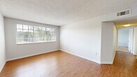 Located at 3544 Saint Johns Bluff Rd S in Jacksonville, FL, this single-floor residence offers a functional and well-organized layout with 2 bedrooms and 2 bathrooms. The spacious living room features warm wood-style laminate flooring, neutral white walls, a textured ceiling, and a large window that fills the space with natural light and offers views of surrounding greenery. The galley-style kitchen is efficiently designed with white cabinetry, granite-look countertops, wood-style flooring, and black appliances including a refrigerator, stove, and dishwasher. Both bedrooms are carpeted in a neutral tan tone and each features a window with views of lush outdoor foliage, offering a calm and bright atmosphere. The primary bedroom includes access to a dedicated walk-in closet outfitted with wire shelving and hanging rods, providing generous storage. The two full bathrooms are identically appointed, each featuring a tiled shower-tub combo, wood-style flooring, a vanity with a granite-look countertop, and a white sink. Clean finishes and a consistent neutral color palette are carried throughout the home, creating a cohesive and move-in ready environment.