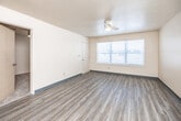 This two-story residence is efficiently organized across two floors, with the larger main level hosting the combined kitchen and living room, while the upper floor accommodates additional bedrooms connected via a central staircase. Throughout the main level, light-toned luxury vinyl plank flooring runs consistently, and textured ceilings with ceiling fans are found in the living areas and select bedrooms, contributing to air circulation and comfort.

The open living room receives natural light through a wide window fitted with blinds, creating a bright and welcoming atmosphere. Adjacent to it, the kitchen features warm honey-toned wood cabinetry, light countertops, and a full suite of black appliances including a refrigerator, range, microwave, and dishwasher, all set over matching LVP flooring.

The four bedrooms are finished with plush carpet and windows that invite natural light. Closet storage is well-represented, including both walk-in and bifold-door closets with wire shelving systems. Both bathrooms are functional and consistent in design, each featuring a tub-shower combination, wood-toned vanity, and light countertops over LVP flooring, providing a clean and practical finish throughout.