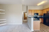 Located at 3575 S Zeno Way in Aurora, Colorado, this single-floor home offers four bedrooms, two full bathrooms, and a practical, well-organized layout. The open-concept living area flows seamlessly from the front entry, featuring plush carpeting and large windows with vertical blinds that allow ample natural light. Built-in corner shelving adds a functional decorative touch to the living space.

The kitchen is positioned centrally and defined by a peninsula with dark countertops, warm honey-toned wood cabinetry, a tile mosaic backsplash, and black appliances including a refrigerator, range, and over-the-range microwave. Wood-look flooring runs through the kitchen and dining area, creating a clean transition from the carpeted living and bedroom spaces.

Each of the four bedrooms is carpeted and features its own closet with sliding panel doors. The primary bedroom is generously sized with vaulted ceilings and a window for natural light. The two full bathrooms are finished with wood-look tile flooring, warm wood vanity cabinetry, and tub-shower combinations with white tile surrounds. A connecting hallway ties the bedroom and bathroom areas together efficiently, rounding out this functional and comfortable home.